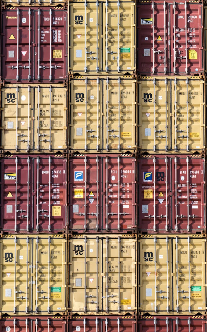 Vertical stack of red and yellow shipping containers, illustrating global logistics.